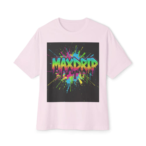 A light pink short-sleeve t-shirt with a large square graphic on the chest. The graphic features the word 'MAXDRIP' in a vibrant, dripping neon paint style with splatters of pink, blue, yellow, and green on a black background.